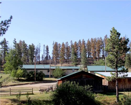 photo of home with a defensible landscape and a metal roof
