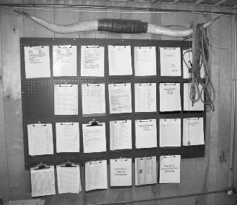 Records organized on wall with clipboards