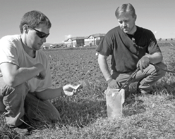 A photo of two men calibrating a ground sprayer.