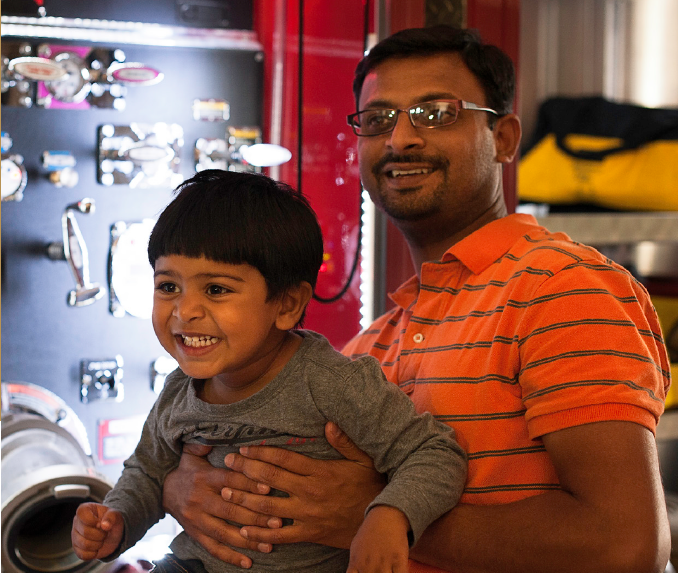 A man holds his son as both smile at a Dynamic Dads event