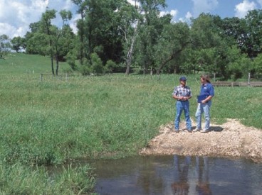 Two people talking at the edge of a body of water
