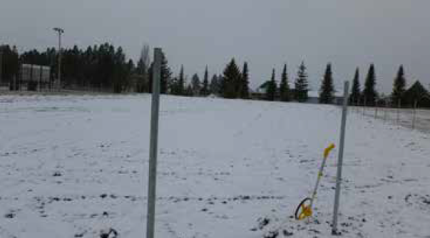 A measuring device is seen out in a snowy field before it is planted